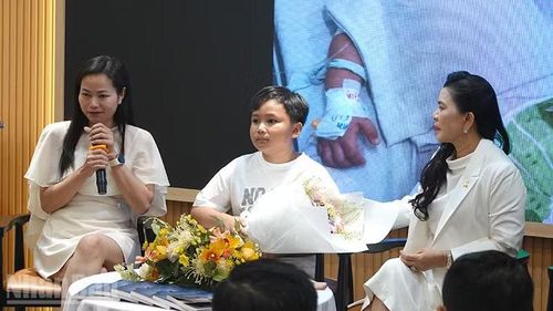 Bé Nguyễn Phan Trọng Nhân và mẹ (bìa trái) tại lễ ra mắt tủ sách.