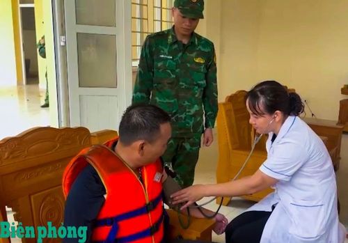 Cán bộ Đồn Biên phòng Thanh Lân phối hợp với cán bộ y tế kiểm tra sức khỏe ngư dân. Ảnh: Xuân Hùng