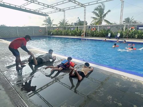 Anh Hồ Lê Thịnh - Huấn luyện viên Câu lạc bộ bơi lội Đức Hòa, giáo viên Trường Tiểu học Lê Minh Xuân (tỉnh Tây Ninh) đang dạy bơi cho các học sinh.