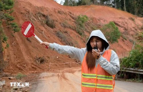 Lực lượng túc trực hàng ngày để cảnh báo, điều tiết các phương tiện trong quá trình thi công khắc phục sạt lở. (Ảnh: Nguyễn Dũng/TTXVN)
