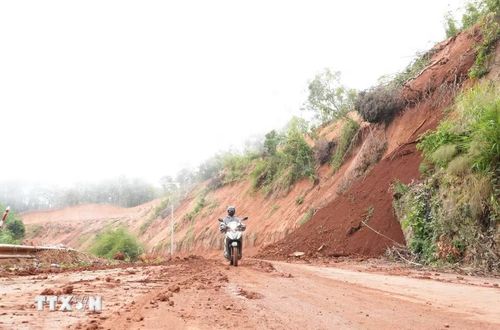 Một số phương tiện xe máy của người dân địa phương được linh động cho di chuyển qua đoạn tuyến đang thi công trên đèo Gia Bắc sau khi đã đảm bảo an toàn. (Ảnh: Nguyễn Dũng/TTXVN)