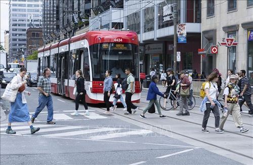Người dân di chuyển trên đường phố tại Toronto, Ontario, Canada. Ảnh tư liệu: THX/TTXVN