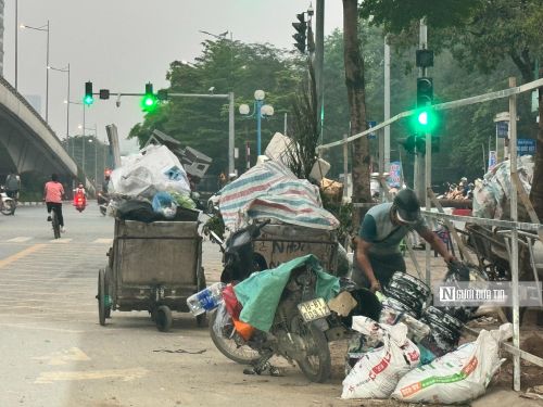 Một só người dân tận thu các thùng nhựa tại điểm tập kết rác ở phường Nghĩa Đô, thành phố Hà Nội.