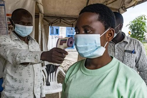 Một nhân viên y tế tại cửa khẩu Busunga giữa Uganda và Cộng hòa Dân chủ Congo kiểm tra thân nhiệt của một du khách. Ảnh: AFP/Getty Images