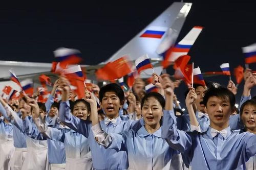 Học sinh sinh viên Trung Quốc chào đón Tổng thống Nga ở sân bay. Ảnh: RiaNovosti