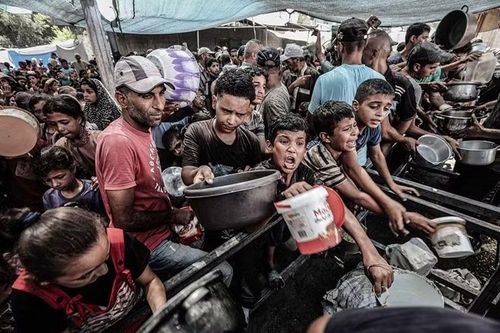 Người Palestine, phần lớn là trẻ em, chen nhau tại một điểm phát đồ ăn từ thiện ở Gaza. Ảnh: Anadolu Ajansi.