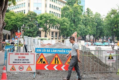 Người dân lưu thông qua khu vực công trường đang triển khai dự án xây dựng hệ thống thoát nước chống ngập khu vực nội đô Hà Nội. Ảnh: Phạm Tuấn Anh - TTXVN