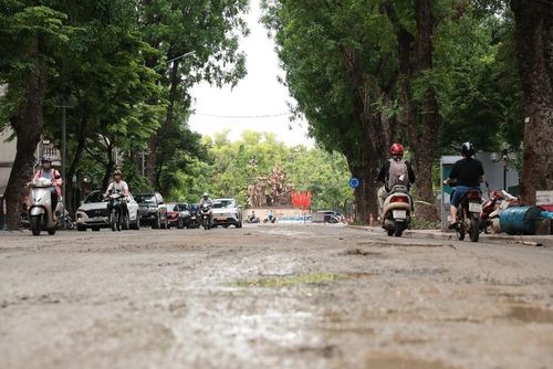 Mặt đường phố Quang Trung chưa hoàn thiện sau quá trình thi công hạ tầng thoát nước quanh hồ Thiền Quang, các phương tiện vẫn lưu thông qua khu vực. Ảnh: Phạm Tuấn Anh - TTXVN