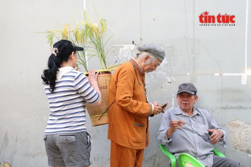 Không ít người dân tò mò, dừng lại hỏi han về bộ trang phục mới cùng chiếc gùi ông Thái đeo sau lưng trong lúc bán vé số.