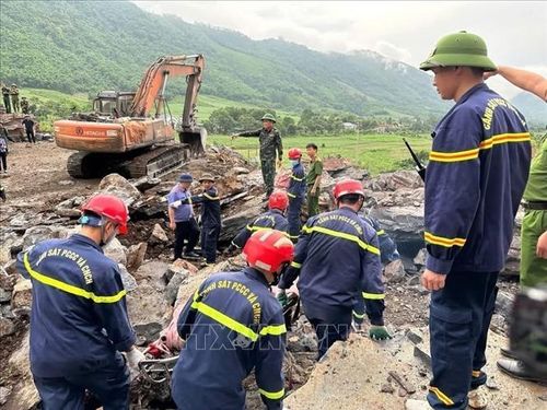 Lực lượng chức năng tìm kiếm 2 nạn nhân bị vùi lấp tại khu vực sạt lở. Ảnh: TTXVN phát