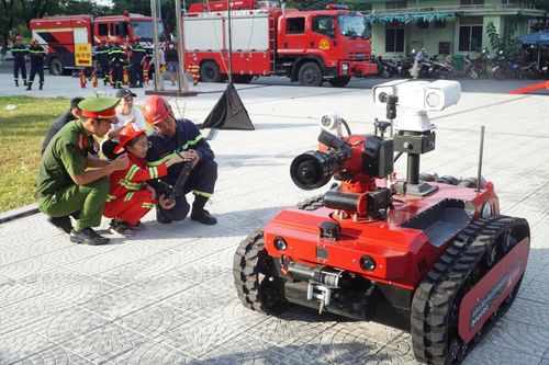 Em Nguyễn Cao Gia Hân thích thú khi được trải nghiệm điều khiển robot chữa cháy. Ảnh: TRUNG ANH