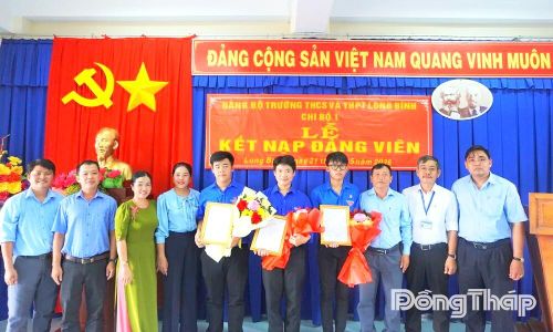 Lãnh đạo xã Long Bình, lãnh đạo nhà trường chụp ảnh lưu niệm cùng các đảng viên tại buổi lễ