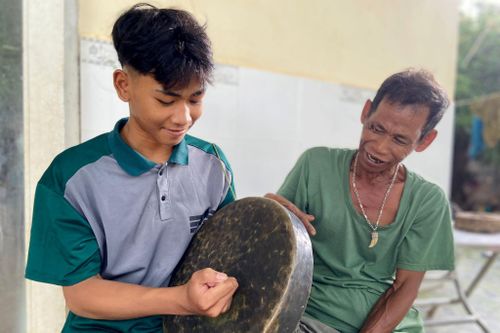 Nghệ nhân Y Xuyên (bên phải) truyền dạy chiêng cho con cháu