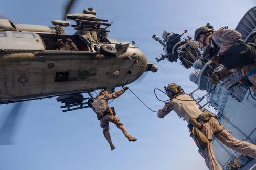  Các binh sĩ Thủy quân lục chiến Mỹ đu dây từ trực thăng MH-60S Sea Hawk trong quá trình huấn luyện duy trì hoạt động bằng trực thăng và đu dây trên tàu đổ bộ USS Tripoli công (LHA 7), ngày 8/5. Ảnh: Thủy quân lục chiến Mỹ. 