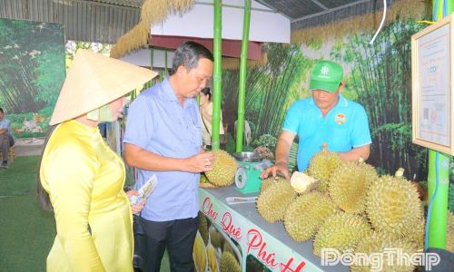 Bí thư Đảng ủy Lê Minh Trung và Chủ tịch UBND xã Phú Hựu Võ Thị Bình tham quan, kiểm tra chất lượng những quả sầu riêng đạt chứng nhận OCOP của Hợp tác xã Sầu riêng Phú Hựu.