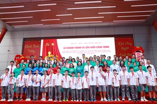 Lãnh đạo thành phố và phường Giảng Võ cùng thầy trò trường THCS Giảng Võ 2 tại lễ khánh thành và gắn biển công trình, ngày 21-5. Ảnh: GV
