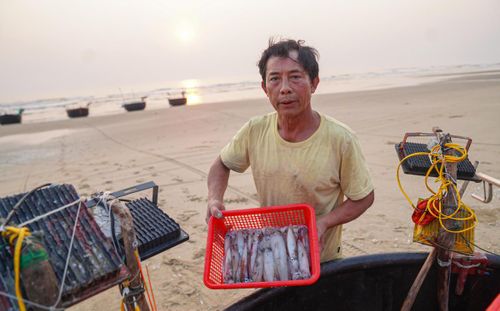 Hải sản vừa đánh bắt được ông Nguyễn Văn Lê phân loại, bảo quản ngay trên bờ để kịp bán cho thương lái. Ảnh: Cẩm Kỳ.