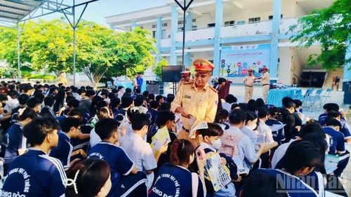 Cán bộ Phòng Cảnh sát giao thông Công an tỉnh Cà Mau phát tờ rơi tuyên truyền cho các em học sinh tại trường Trung học phổ thông Sông Đốc (xã Sông Đốc, tỉnh Cà Mau).