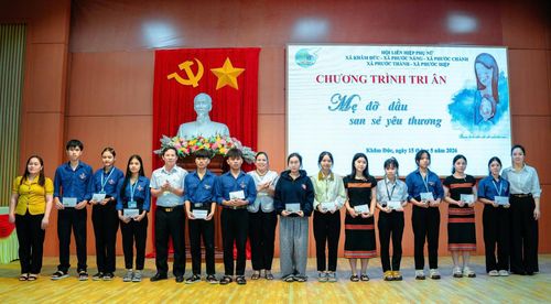 Đại diện chương trình "Mẹ đỡ đầu" và Hội Liên hiệp Phụ nữ xã Phước Năng tặng quà cho các em học sinh. Ảnh: P.V