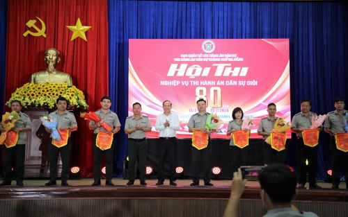 Ban tổ chức tặng hoa, cờ lưu niệm cho các đơn vị dự thi. Ảnh: ALĂNG NGƯỚC