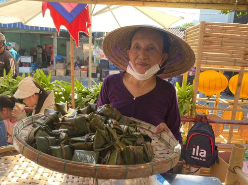 Người dân giới thiệu món bánh ú đến du khách. Ảnh: VĨNH LỘC