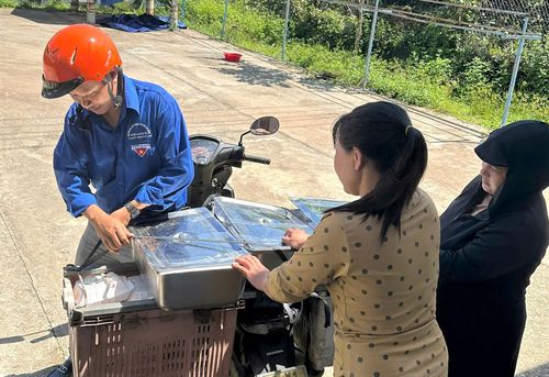 Tình nguyện viên chuyển cơm đến các điểm trường hỗ trợ học sinh. Ảnh: TRÀ VÂN
