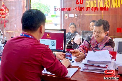 Cán bộ Trung tâm Phục vụ hành chính công phường Mộc Châu hướng dẫn người dân nộp hồ sơ trực tuyến.