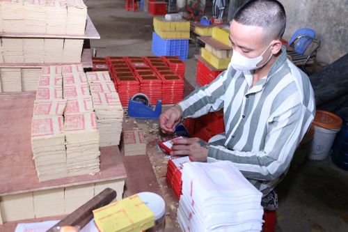 Một phạm nhân đang thực hiện công việc gấp vàng mã.
