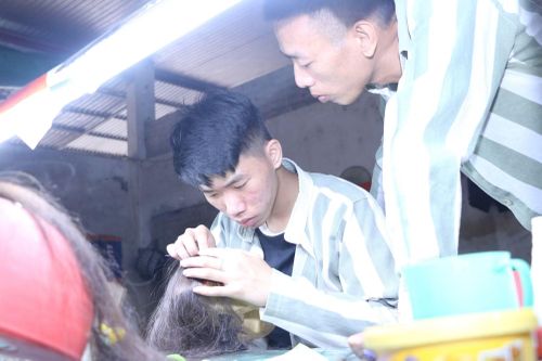 Một phạm nhân đang hướng dẫn nghề làm tóc giả cho người mới vào.