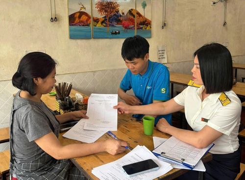 Cán bộ thuế hướng dẫn hộ kinh doanh kê khai trước khi có chính sách mới. Ảnh: PV