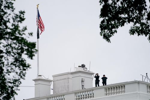 Mật vụ Mỹ canh gác trên mái Nhà Trắng sau vụ nổ súng ngày 23/5. Ảnh: Reuters.