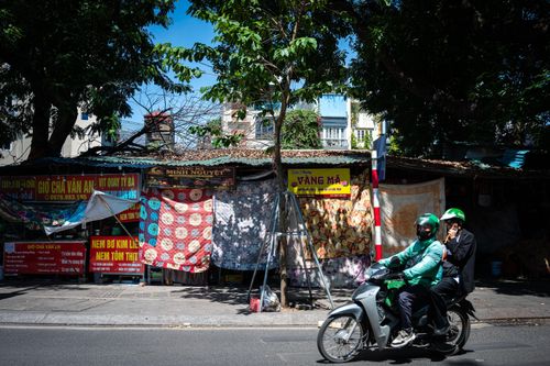  Nhiều hộ kinh doanh mặt đường phải căng bạt, dựng mái che hoặc dùng ô lớn để chắn nắng trực tiếp. 