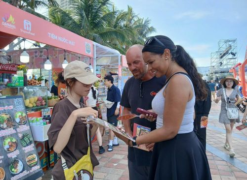 Du khách nước ngoài tìm hiểu các món ăn đặc trưng xứ Quảng tại Lễ hội Food Tour Đà Nẵng 2026. Ảnh: Mỹ Hà - TTXVN