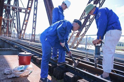 Công nhân đang triển khai bảo dưỡng hệ thống đường sắt trên cầu Long Biên giữa trưa nắng tới 40 độ. Ảnh: Hoàng Hiếu - TTXVN