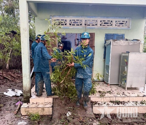 Lực lượng dân quân Ban CHQS phường Giá Rai hỗ trợ người dân dọn dẹp nhà sau dông lốc.