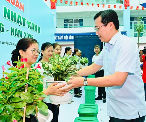 Phó Bí thư Thường trực Thành ủy TPHCM Lê Quốc Phong trao tặng cây xanh đến người dân. Ảnh: VIỆT DŨNG