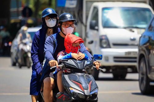 Ai nấy ra đường đều trong trang phục kín mít với khẩu trang và áo chống nắng. (Ảnh: Hoài Nam/Vietnam+)