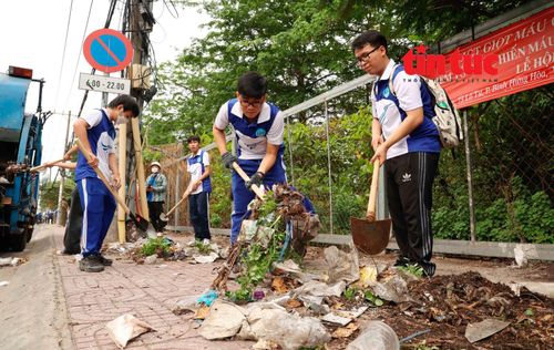 Sinh viên trường Đại học Sài Gòn hỗ trợ dọn dẹp vệ sinh môi trường khu vực dân cư sau lễ ra quân.
