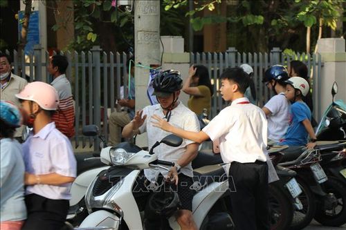 Phụ huynh đưa đón con đến tham dự Kỳ thi. Ảnh: Khoa Chương/TTXVN