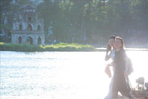 Đến 17h30, nền nhiệt tại Hà Nội vẫn duy trì ở mức cao kết hợp với ánh nắng gay gắt phản chiếu từ mặt hồ khiến nhiều người dân di chuyển qua khu vực Phố đi bộ Hồ Gươm cảm thấy khó chịu.