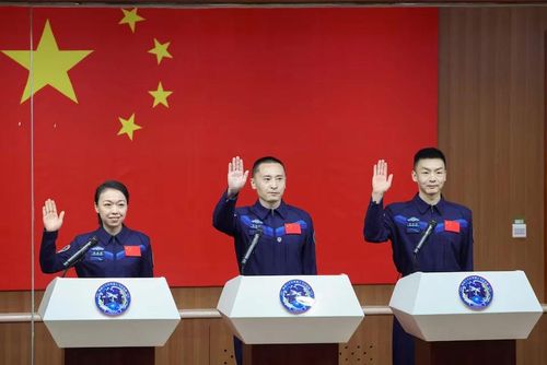 Các phi hành gia Chu Dương Chúc (Zhu Yangzhu), Trương Chí Viễn (Zhang Zhiyuan) và Lại Gia Oánh (Lai Ka-ying), người là phi hành gia đầu tiên đến từ Hong Kong, vẫy tay khi tham dự cuộc họp báo trước sứ mệnh bay vũ trụ Thần Châu-23 tới trạm không gian Thiên Cung của Trung Quốc, tại Trung tâm Phóng vệ tinh Tửu Tuyền, gần thành phố Tửu Tuyền, tỉnh Cam Túc, Trung Quốc, ngày 23/5/2026. Ảnh: Reuters