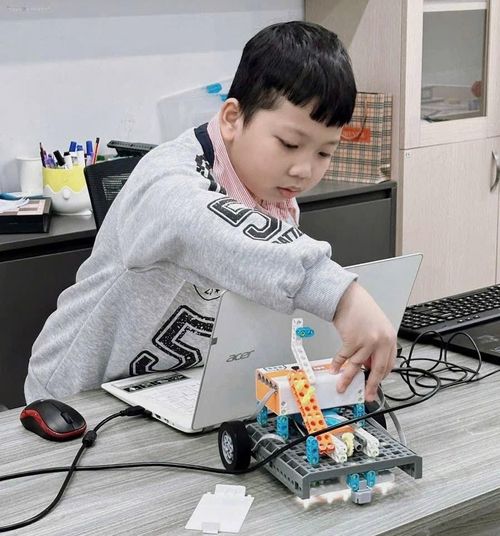 Em Trần Vạn Sơn hào hứng lắp ráp và điều khiển mô hình robot tại lớp học Robotics. Ảnh: HOÀNG LINH