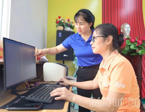Cán bộ xã Vạn Xuân hướng dẫn người dân khu 22 sử dụng hệ thống văn bản trên máy tính.
