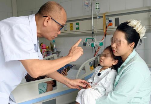 PGS.TS Nguyễn Hồng Hà khám cho bệnh nhi sau phẫu thuật. Ảnh: BVCC