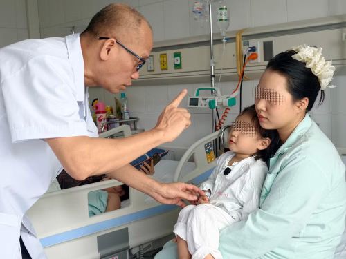 Phó Giáo sư, Tiến sĩ Nguyễn Hồng Hà thăm khám cho người bệnh sau ca phẫu thuật.
