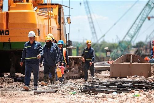 Nhóm công nhân tranh thủ di chuyển, nghỉ ngắn giữa ca làm việc ngoài trời tại công trường xây dựng. Ảnh: Phạm Tuấn Anh/TTXVN