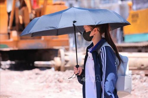 Người dân tìm mọi cách chống nắng khi phải di chuyển trên đường. Ảnh: Hoàng Hiếu/TTXVN