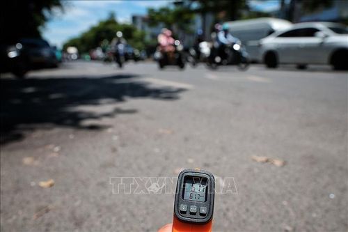 Thiết bị đo nhiệt cho thấy nhiệt độ bề mặt mặt đường ngoài trời lên tới hơn 61 độ C vào thời điểm giữa trưa ngày 25/5. Ảnh: Phạm Tuấn Anh/TTXVN