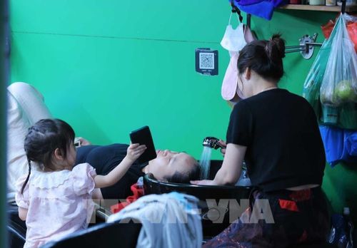 Người dân đến chợ Trương Định để gội đầu, làm mát cơ thể để chống chọi với thời tiết nắng nóng gay gắt tại Hà Nội. Ảnh: Hoàng Hiếu - TTXVN