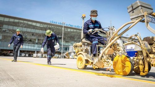 Nhân viên bảo trì đang sơn lại vạch chỉ đường để cho việc cất, hạ cánh máy bay được thuận lợi, an toàn.